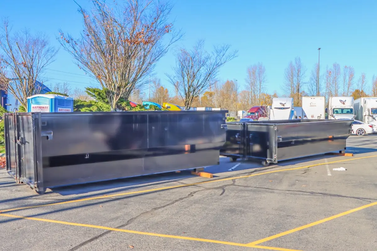 Professional dumpster rental service with roll-off container on residential driveway in Holliston